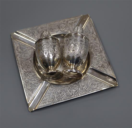 A Persian white meal engraved ashtray, 120 grams and a Persian engraved salt and pepper pot, 99 grams (3) 219 grams gross.